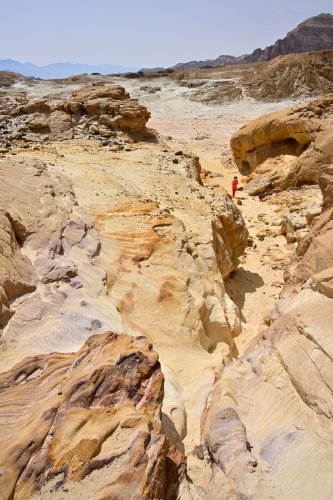 Parc national de Timna (Israël) - Personnage dans petit canyon dans paysage de grès colorés érodés (VO-23-0350)