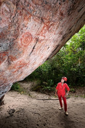 Monte Alegre (Pará, Brésil) -  Personnage regardant des peintures préhistoriques  sur la paroi d'un abri sous roche du le Parque Estudeal de Monte Alegre (VO-23-0892)