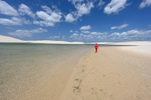 Lençois de Maranhenses (Maranhao, Brésil) - Personnage en rouge marchant sur la berge d'un lac avec dunes de sable blanc en fond(VO-23-1115)