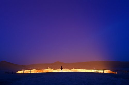 Cratère de Darvasa - Porte de l'Enfer (province d'Ahal, Turkménistan) - Halo de lumière au dessus du cratère la nuit (personnage en premier plan).(VO-26-0847)
