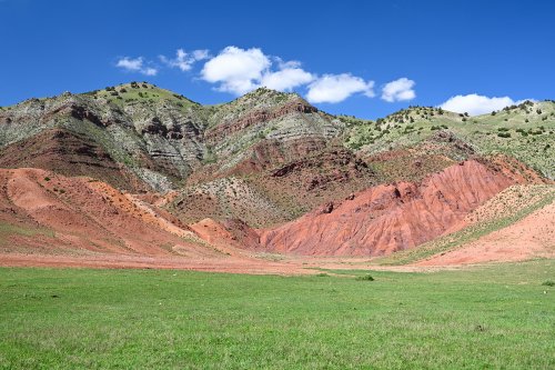 Région du Köytendag (Turkménistan) -  Montagnes colorées dans le secteur du Plateau des Dinosaures (prairie verte en premier plan).(VO-26-1062)