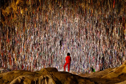 Région du Köytendag (Turkménistan) - Grotte de Kyrk Gyz (ou des 40 Vierges) : personnage de dos devant une paroi couverte de rubans multicolores.(VO-26-1104)