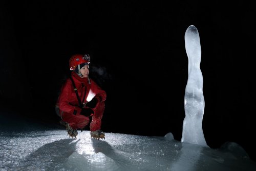 Eiskogelhöhle (Tennengebirge, Autriche) - Spéléologue devant stalagmite de glace)(SP 11-0522)