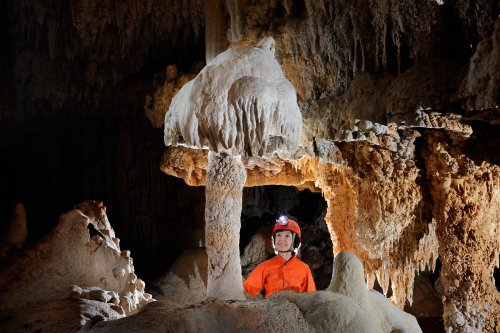 Cueva de Santa Catalina (Expédition Cuba 2012 - Team La Salle). Spéléo derrière une concrétion en forme de champignon.(SP-12-0110)