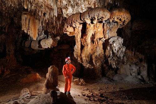 Cueva de Santa Catalina Expédition Cuba 2012 - Team La Salle. Spéléo à côté de concrétions en forme de trois champignons suspendus.(SP-12-0119)