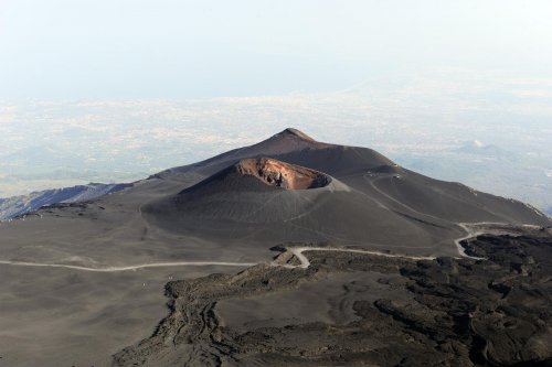 Volcan de l'Etna (Sicile, Italie) - La piste pour les 4X4 passe au pied de La Montagnola, un cratère assez ancien et monte vers la Torre del Filosofo. Au fond, la ville de Catane.(vo-08-0382)