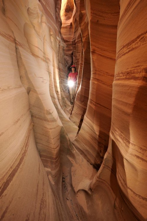 Parc d'EScalante (Utah). Zebra Canyon. Partie étroite avec personnage éclairant avec un flash.(VOY 09-1110)
