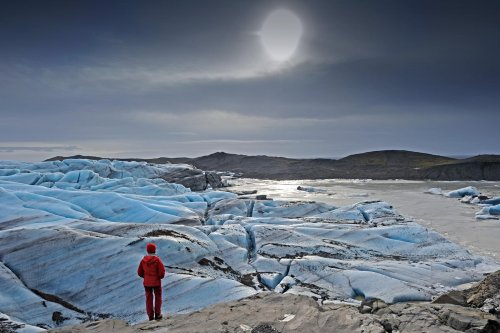Islande (Skaftafell) : lagune au pied du glacier du Svinafellsjokull avec soleil pâle en contre jour(Vo 11-0070)