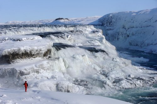 Islande - Cascade de Gullfoss prise par la glace (vue de la rive droite avec personnage en premier plan)(Vo 11-0493)