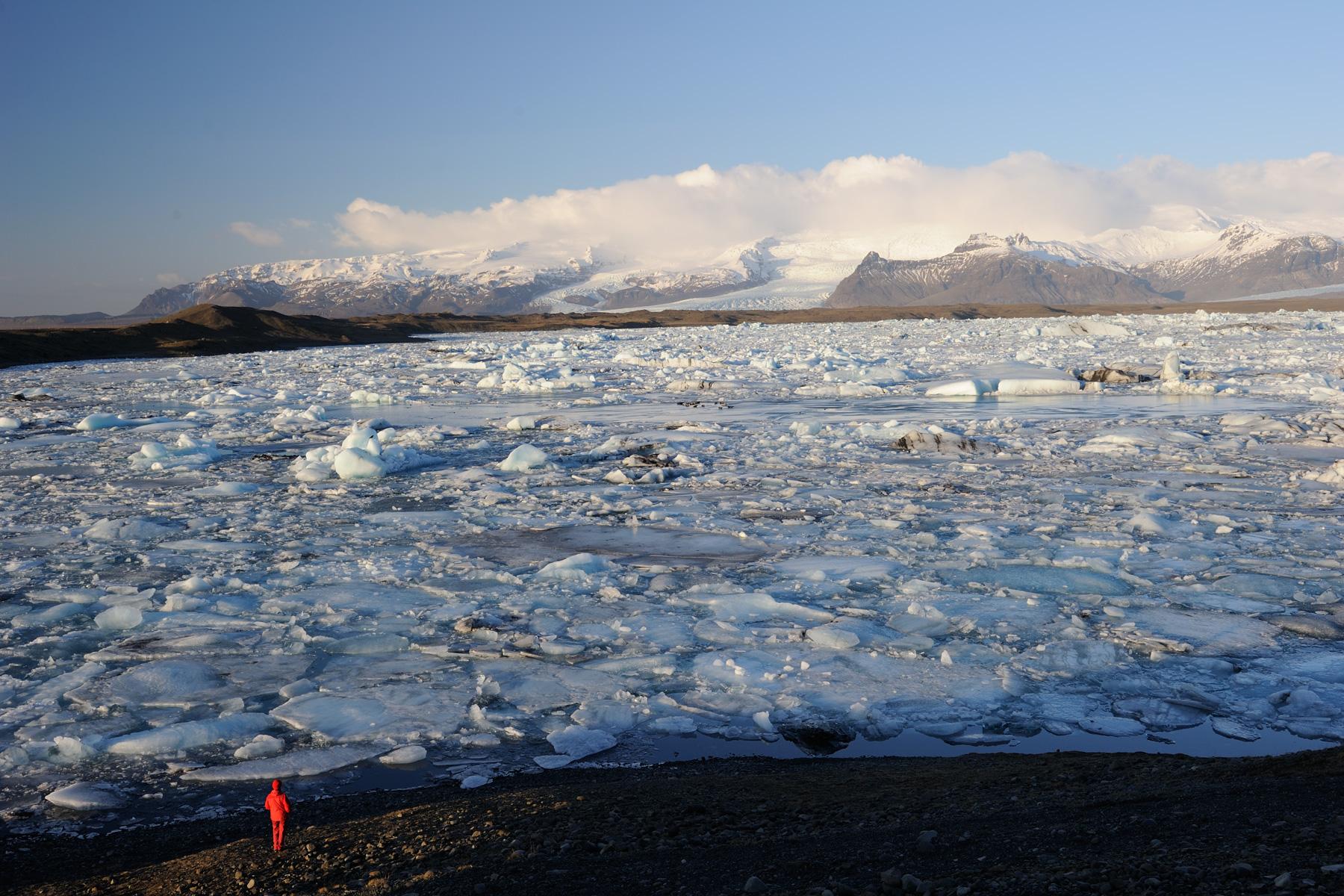 Islande - Lagune du Jokulsarlon envahie par les blocs de glace (vue d'ensemble avec personnage premier plan)