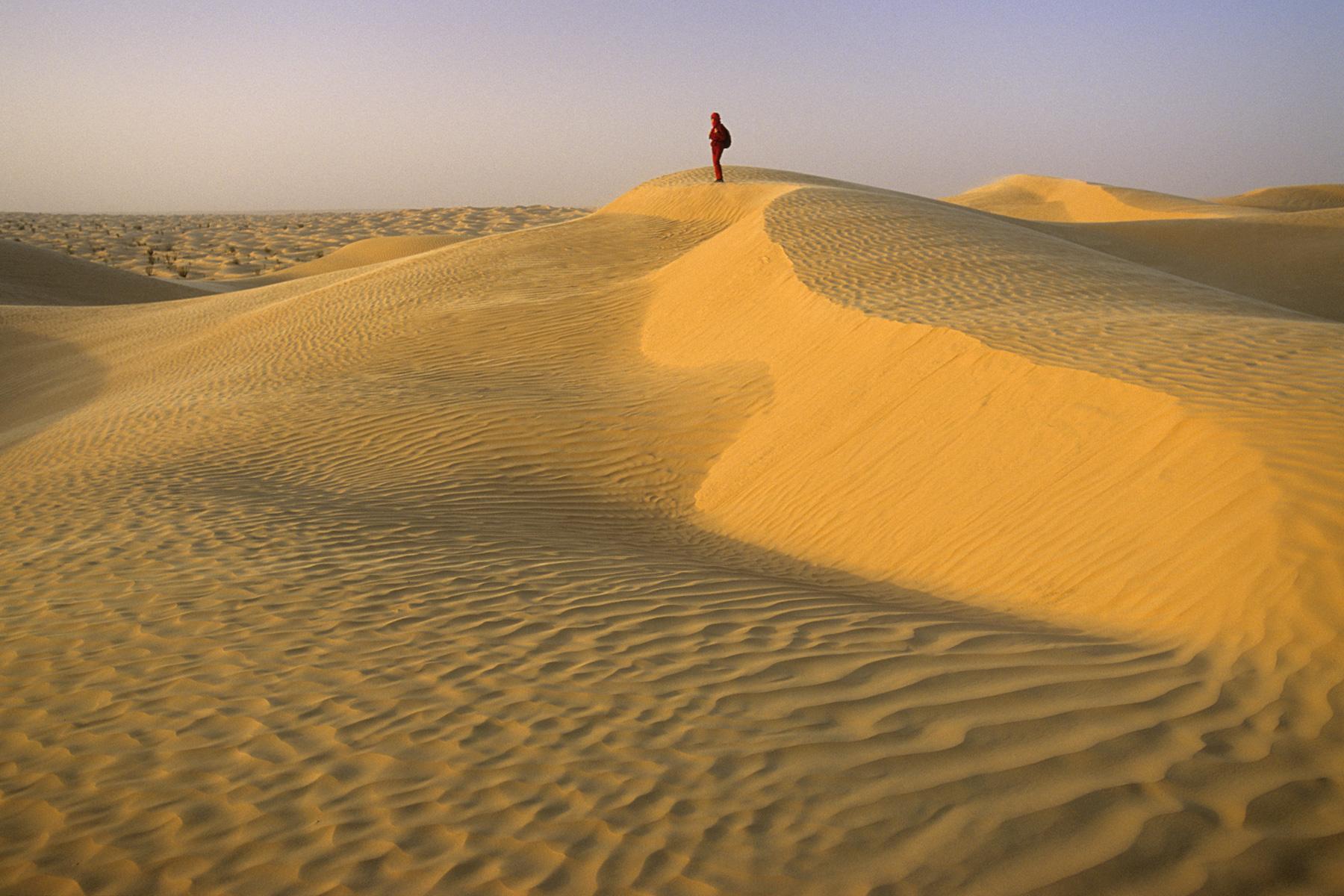 Sud Tunisien. Près de Ksar Ghilane. Coucher de soleil dans les dunes avec personnage perché sur une crête.