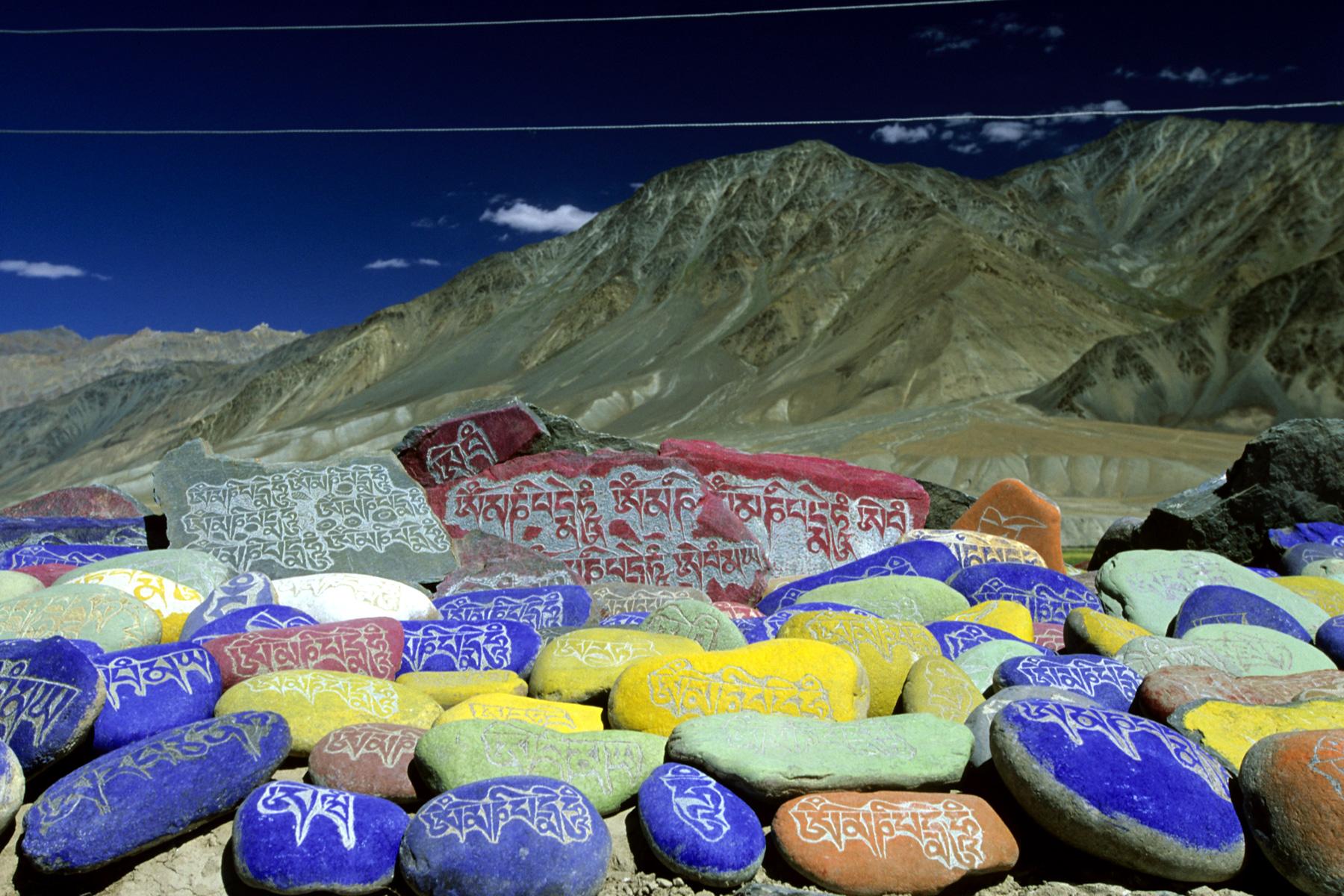 Zanskar. Trek Lamayuru - Padum. Pierres peintes avec des mantra sur un mur à prières à côté de Padum.