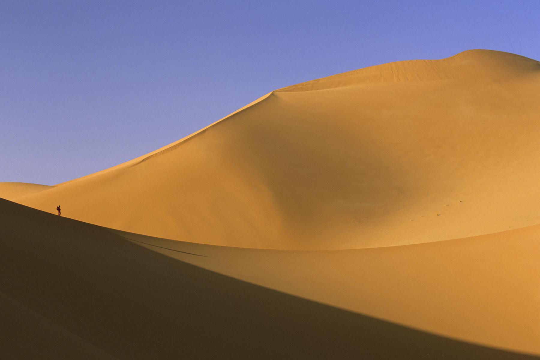 Femme progressant sur la crête d’une dune (Erg Wankasa, Désert de l’Akakus, Lybie)